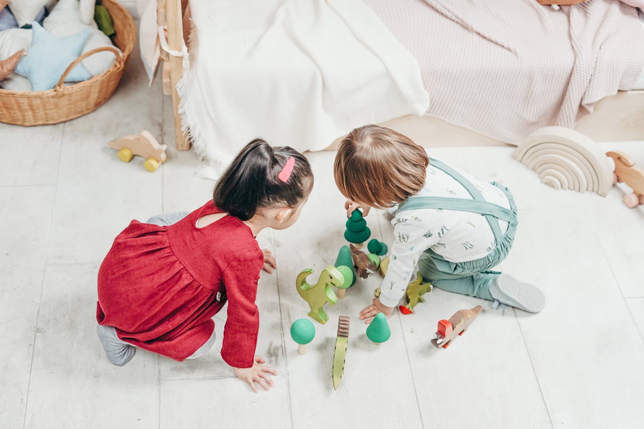 Two children happily playing with wooden toys in a cozy playroom.