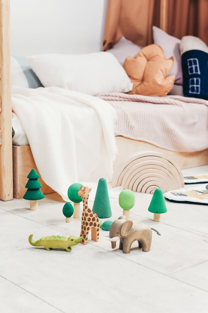 A cozy playroom featuring wooden toys and a bed, creating a warm atmosphere.